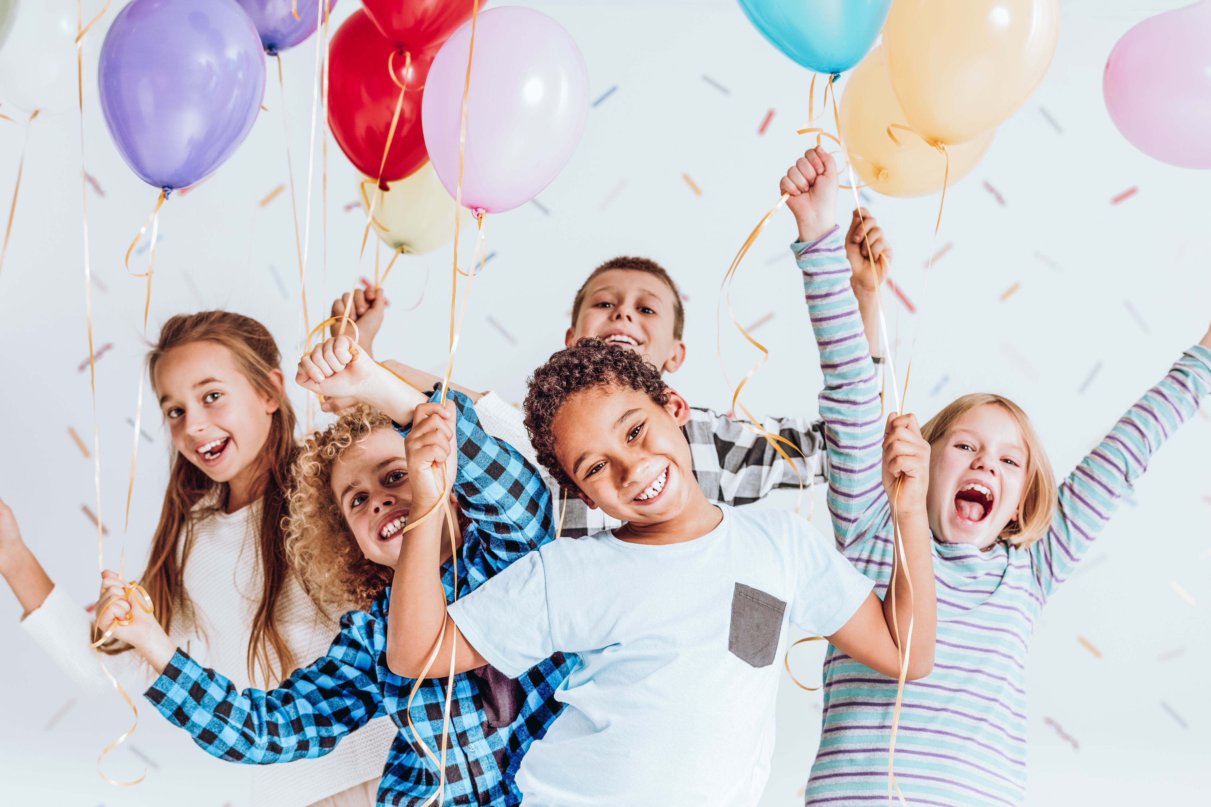 Photography of happy kids with baloons and confetti.